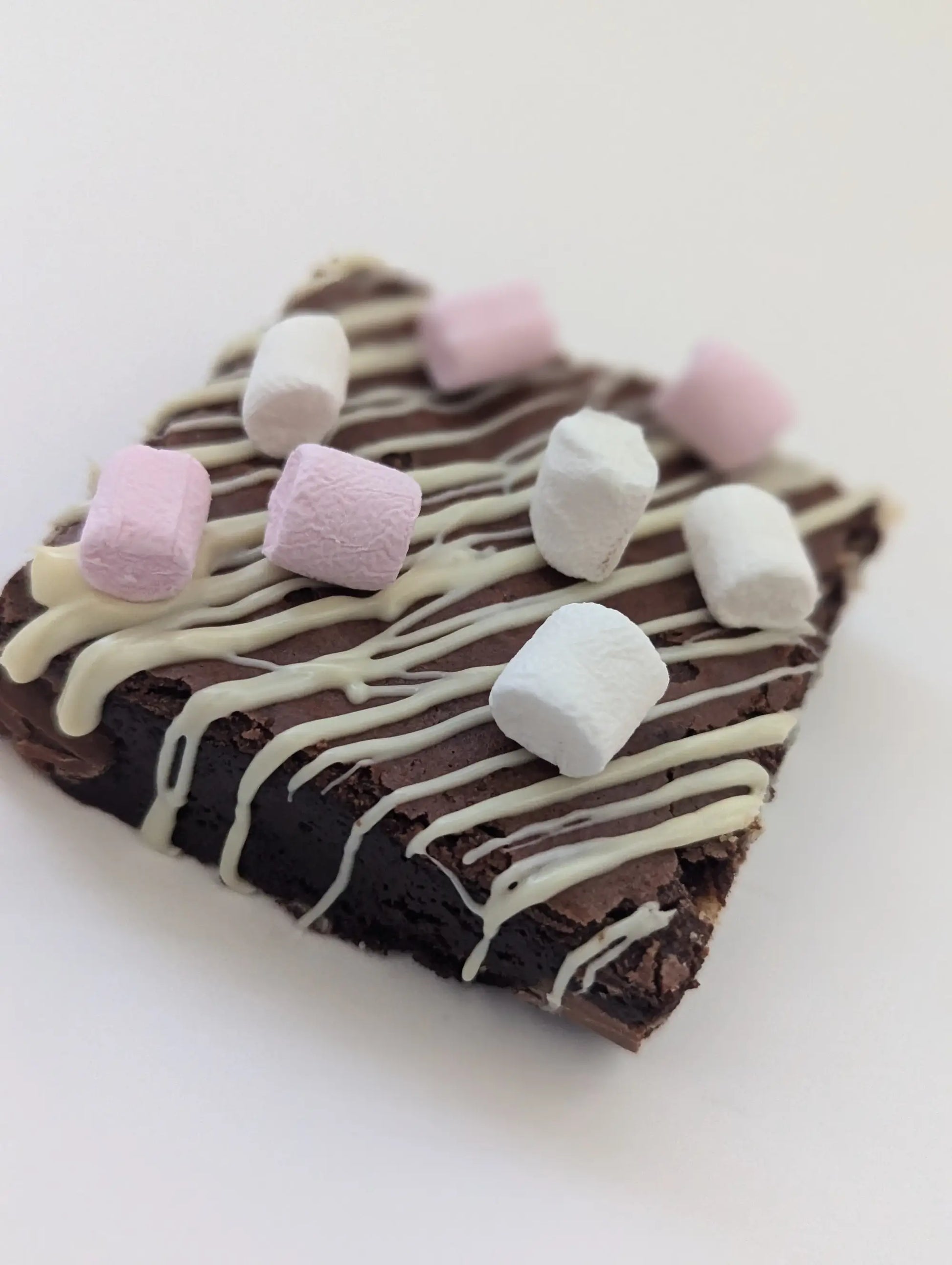 triple chocolate brownie topped with marshmallows and white chocolate