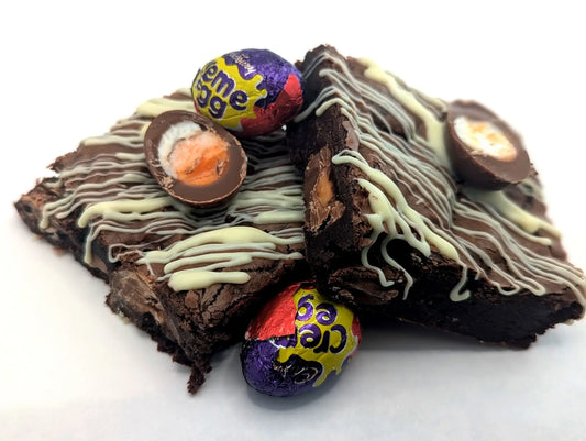 Cadbury's creme egg brownies surrounded by extra creme eggs in their foil
